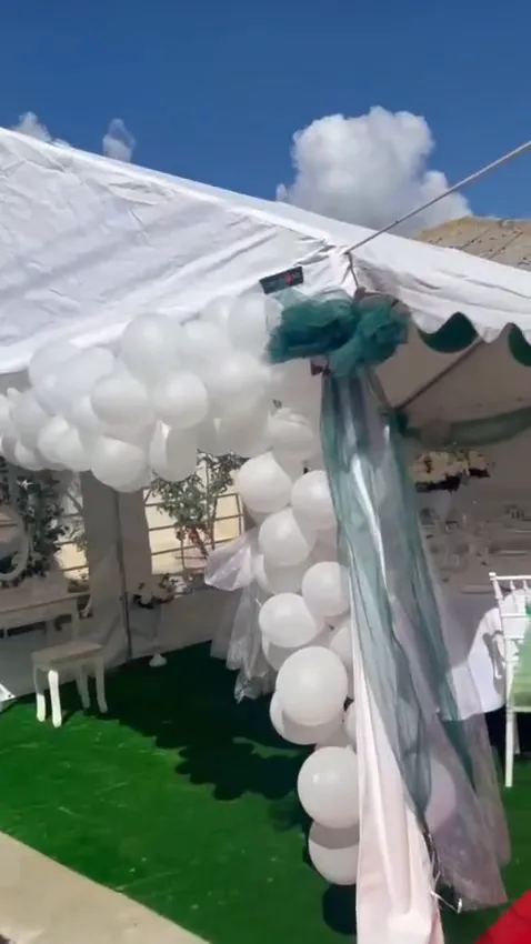 Poster video cu intrarea cortului decorată cu baloane albe și verzi